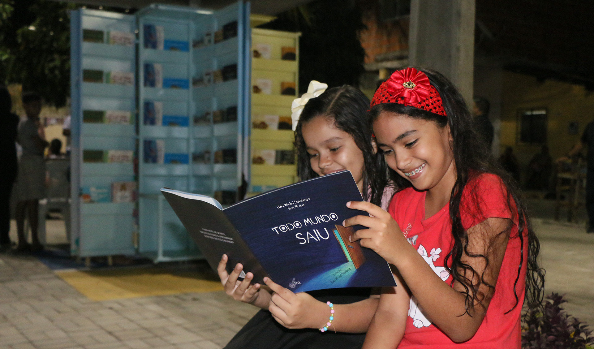 duas meninas lendo um livro infantil